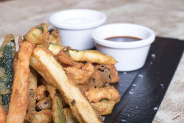 Siyah taş tabakta soslu doğal patates tabağı.