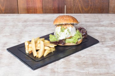 Yumurtalı sebzeli hamburger, marul, domates ve patates.