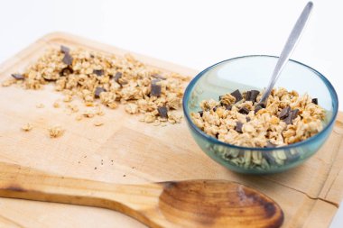 Tahta üzerinde tahta kaşık olan tahıl kasesi.