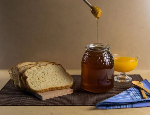 Stilleven Met Natuurhoning Sinaasappelsap Rustiek Brood Honinglepel Die Honingpot Valt — Stockfoto