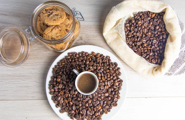 Coffee beans on plate and in coffee bag with cookie jar