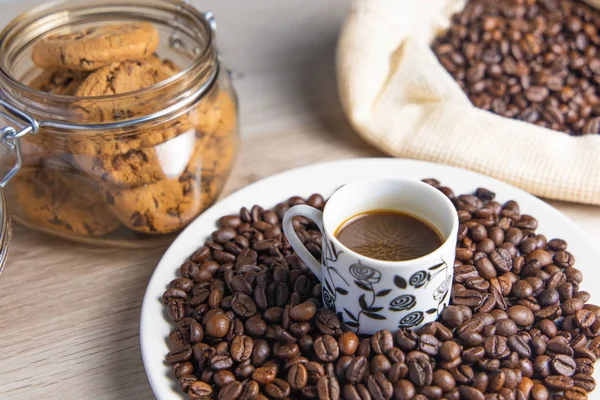 Coffee beans on plate and in coffee bag with cookie jar