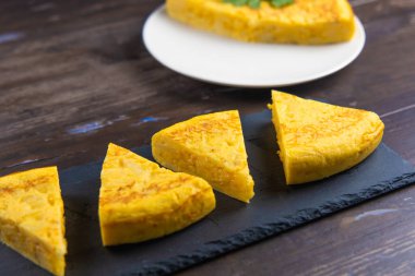 Siyah karatahta tabakta İspanyol patates omleti porsiyonları, orijinal fotoğraf.