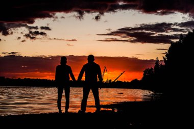 genç bir çift deniz kıyısı üzerinde günbatımında aşık