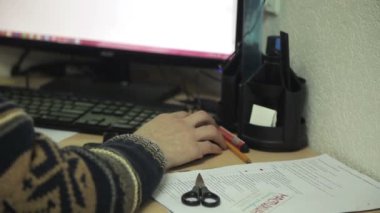 Ofis çalışanı bilgisayarda çalışma masasında bir süveterli fare imlecini hareket