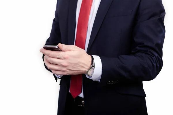 Close-up of a man in a suit holds a mobile phone, on his left hand a watch, on a white background — Stock Photo, Image