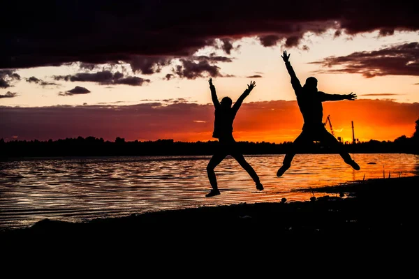 Heureux de deux amies sautant et silhouette coucher de soleil avec espace de copie . — Photo