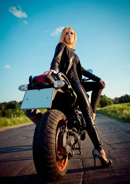 Motociclista chica se sienta en una motocicleta Imagen de archivo