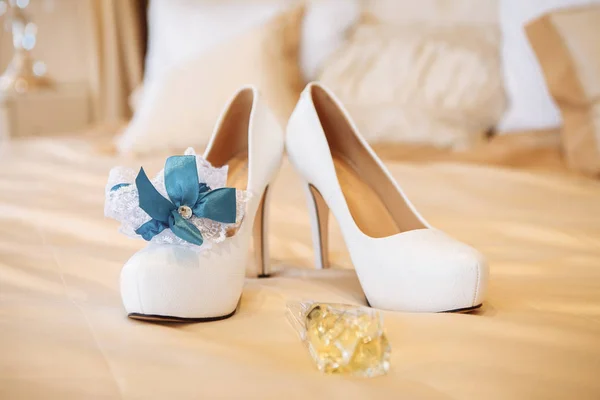 Chaussures de mariée blanches, jarretière et alliances. focus sélectif — Photo