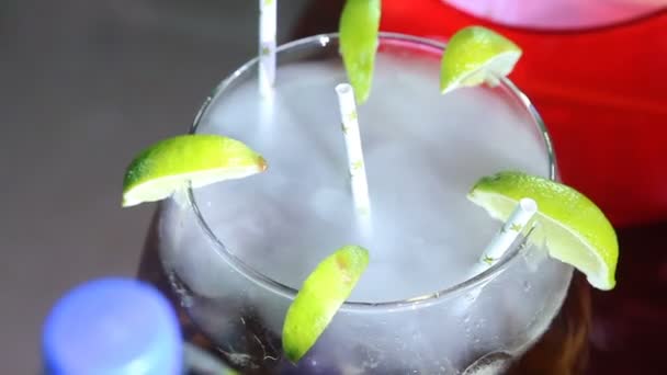 Cocktail dans un verre à la chaux divisé en tranches sur un verre, avec des tubes blancs, à l'intérieur d'un nuage moléculaire de fumée de verre — Video