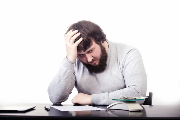 L'employé est fatigué, sa main droite a appuyé sa tête, la gauche est allongée sur la table, l'endolaire, sur un fond blanc — Photo