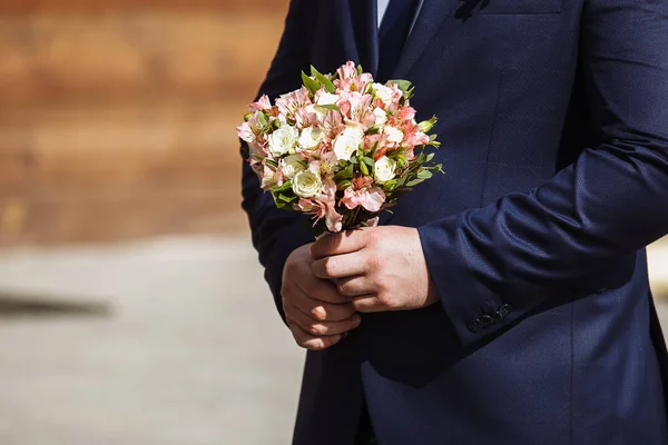 Junger hübscher Bräutigam im dunkelblauen Anzug, der allein im Freien steht — Stockfoto