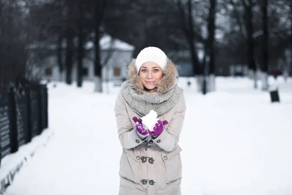 Bonita chica lanzando una bola de nieve —  Fotos de Stock