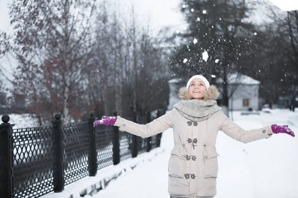 Mädchen in warmer Winterkleidung und Hut, der im Wald Schnee weht, waagerecht — Stockfoto