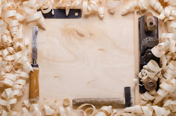 Wood shavings on a wooden background with tools — Stock Photo, Image