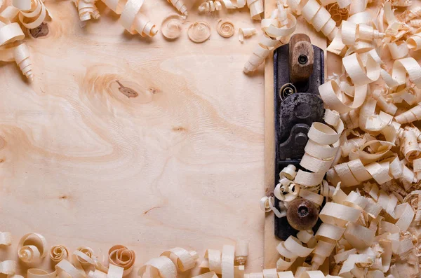 Wood shavings on a wooden background with tools — Stock Photo, Image