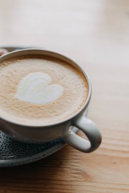 Bir bardak kapuçino, ahşap üzerinde. 