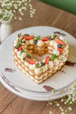heart shaped cake with berries and flowers