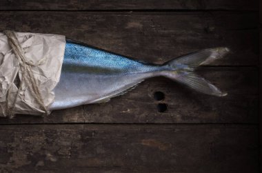 Tahta arka planda sarı karınlı ton balığı.