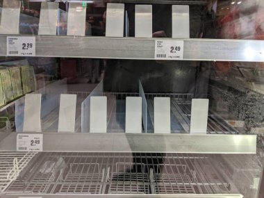 Salgın koronavirüs salgını nedeniyle panikledikten sonra süpermarketteki dondurucu bölmelerinde boş dolaplar.