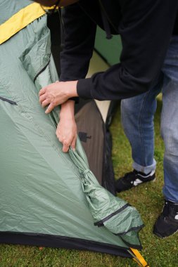 Kamp için çadır kuran bir adamın yakınına.               