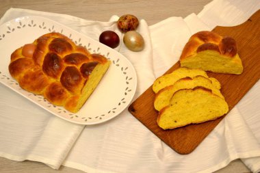 Paskalya çöreği kabak ezmesi hamuruyla örülmüş yumurta, arka planda paskalya yumurtası.