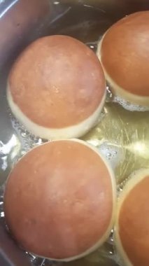 Ev yapımı çörekler; ikinci tarafta mayalanmış hamur topları kızartma..