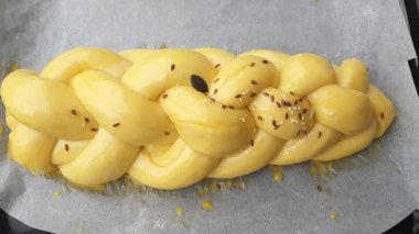 Challah - örgülü brioche hamur pişirmeye hazır; tohum karışımı serpiştirme