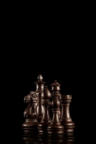 Sakk-készlet. Stratégia és a vezetői koncepció; fekete fa sakk alak állt össze, mint egy család, készen áll a játék sötét háttér. — Stock Fotó
