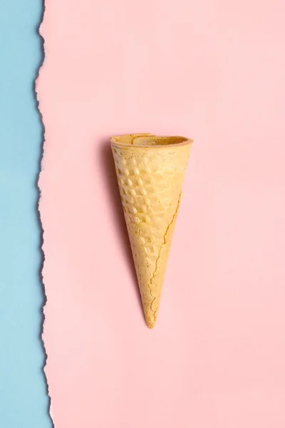 Sweet cone. Creative still life of a sweet empty wafer cone on torn wall papers background. — Stock Photo, Image