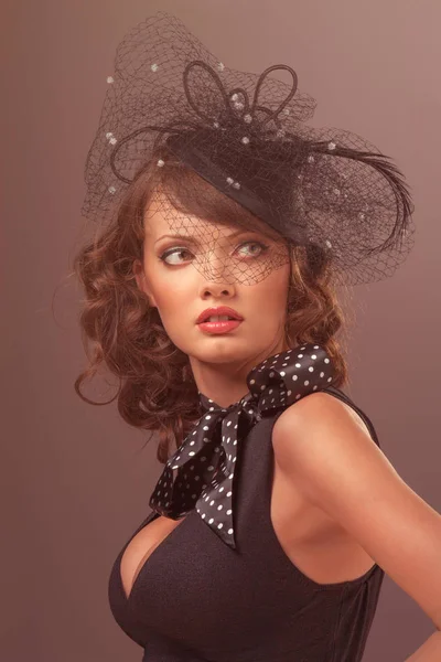 Losgelöste Schönheit. Porträt eines hübschen Retro-Mädchens in Schwarz mit niedlichem Hut und Schal. — Stockfoto
