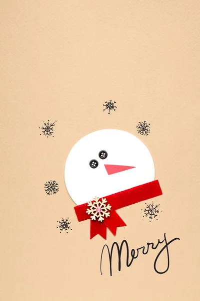 Vrolijk kerstfeest. Creatieve foto's voor een gekke sneeuwman papier op bruine achtergrond. — Stockfoto