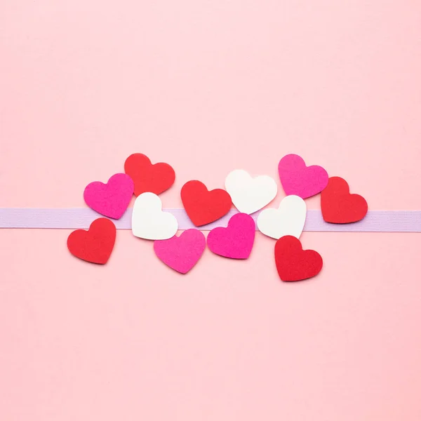 Valentine card. Creative valentines concept photo of hearts made of paper on pink background.