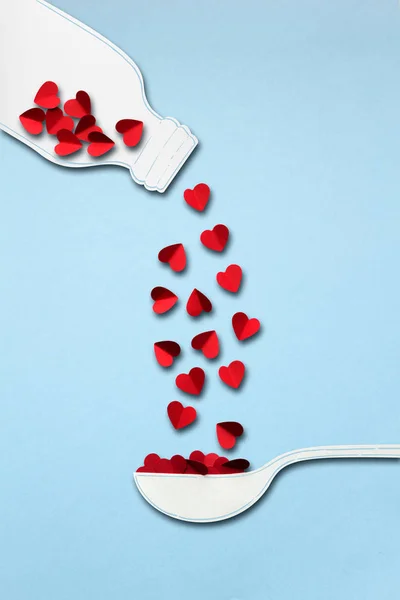 Liefde de brouwsel. Creatieve valentines concept foto van de fles en lepel gemaakt van papier met hart op blauwe achtergrond. — Stockfoto