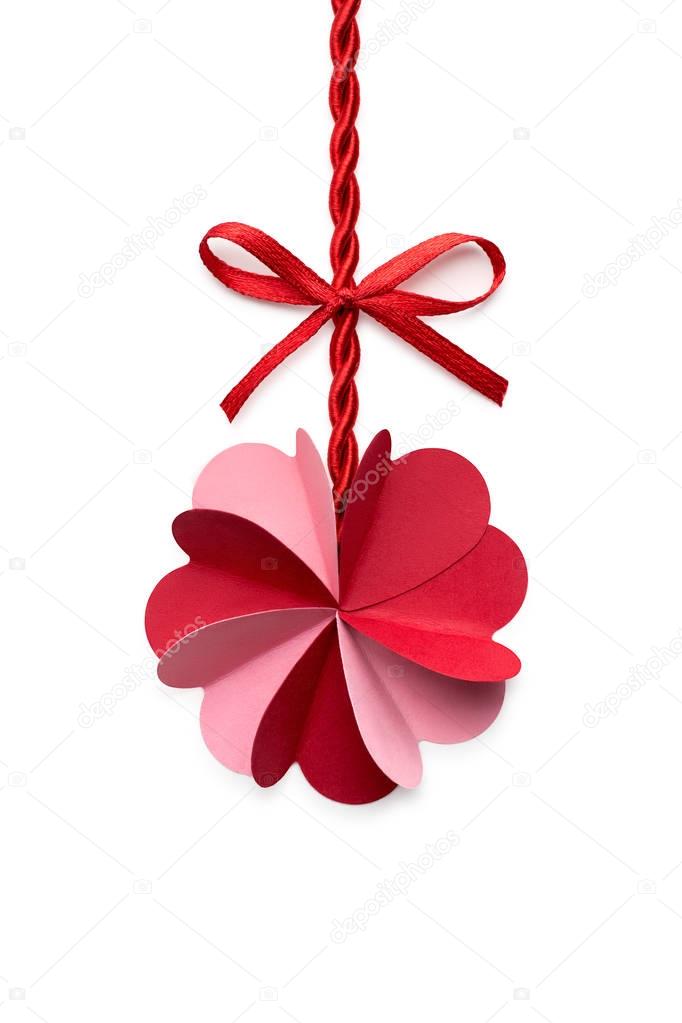 Creative valentines concept photo of a flower made of paper hearts with a rope and a bow on white background.