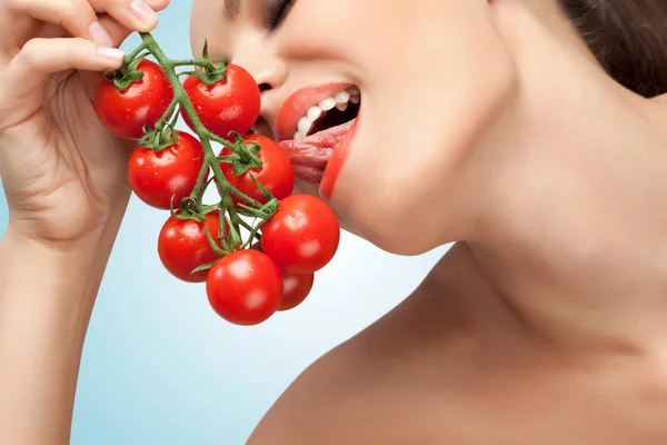 Foto criativa de uma mulher sexy lambendo um monte de tomates cereja — Fotografia de Stock