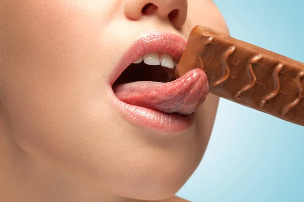 Mujer lamiendo chocolate bar . — Foto de Stock