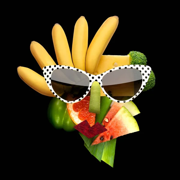 Chutné umění. Bizarní jídla koncept kubistický styl ženské tváře ve sluneční brýle vyrobené z ovoce a zeleniny, na černém pozadí. — Stock fotografie