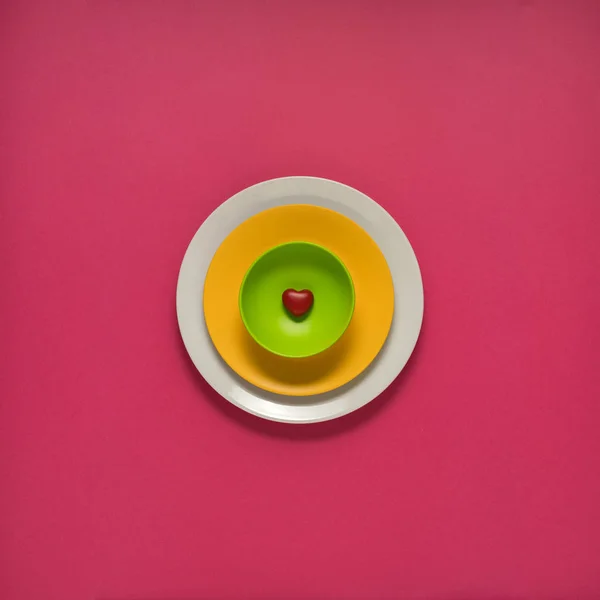 Colorful plates on pink — Stock Photo, Image
