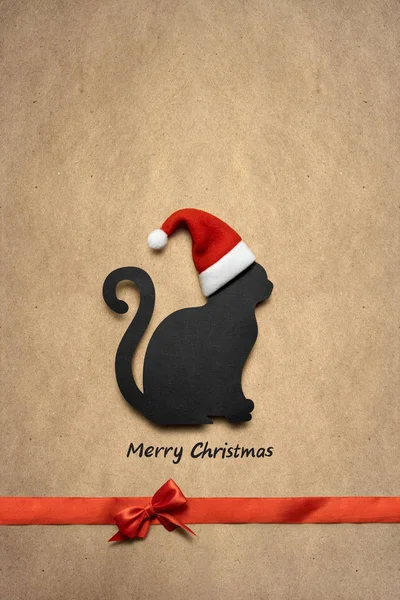 Feliz Natal! Feliz Natal! Foto conceito criativo de gato de Natal no chapéu com sinal no fundo marrom . — Fotografia de Stock