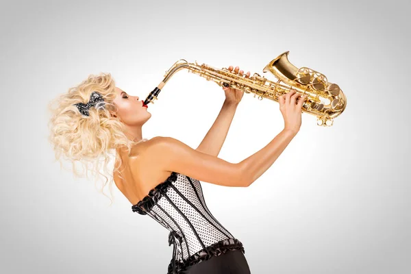 Hrající jazz. Krásný plakát model hrál saxofon na šedém pozadí. — Stock fotografie