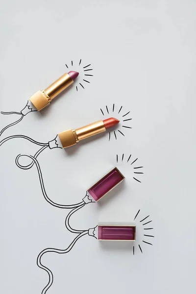 Beautiful holiday. Creative concept photo of lipstick as christmas lights on grey background. — Stock Photo, Image