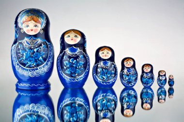 yedi mavi boyalı Rus iç içe geçmiş bebek ayna yüzey üzerinde bir dizi.