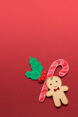 Yaratıcı konsept fotoğraf kırmızı bir arka plan üzerinde Noel şeker ve zencefilli kurabiye adam.