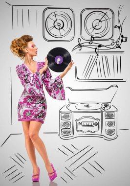 Ellerini bir vintage plak çalar ve vinil toplama yarım yamalak gri arka plan üzerinde mor Lp microgroove vinil kaydını tutan bir moda hippi ev kadını renkli fotoğraf.