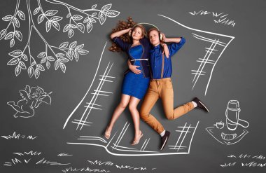 Mutlu Sevgililer romantik bir çift üzerinde kulaklık paylaşımı ve tebeşir çizimleri arka plan müzik dinlemek bir piknik hikayesi kavramını seviyorum.