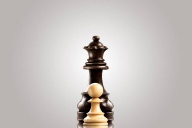 Liderlik ve cesaret kavramı; Beyaz ahşap tek piyon karşı kara Kraliçe kalıyor.