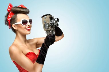 pin-up kızı korse ve eldiven vintage 8 mm kamera tutan bir fotoğraf.