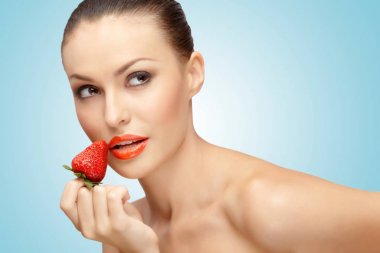 güzel bir kız ile bir yandan sulu çilek dudaklarına günaha ile yakın tutarak yaratıcı portresi.