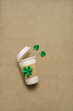 Yaratıcı St. Patricks gün kavramı fotoğrafını çekin uzakta kahve fincanı yoncaları kağıt üzerinde kahverengi zemin ile.